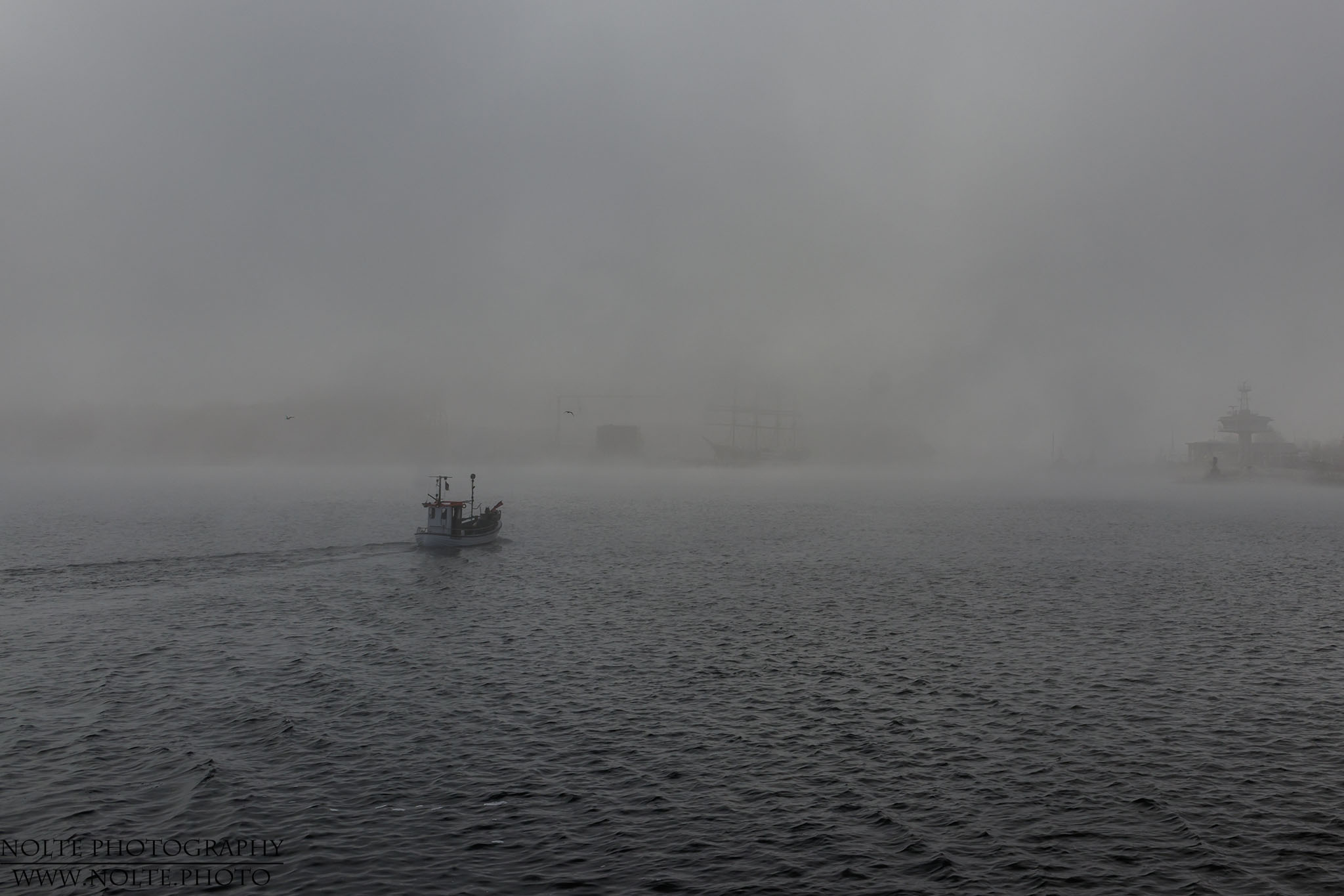 Fischerboot im Nebel